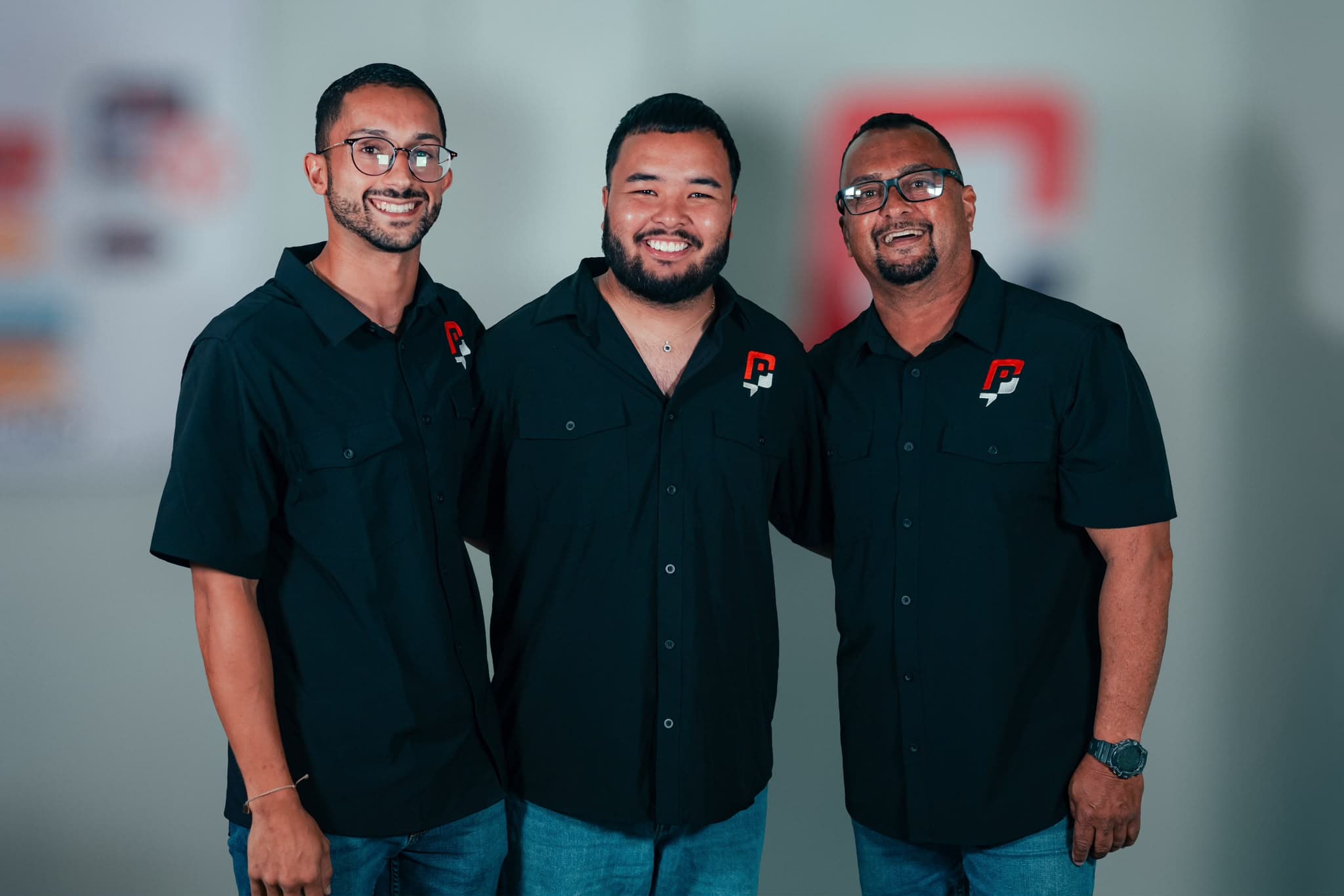 Tres integrantes del equipo de The Print Co. SG con sus uniformes en el taller