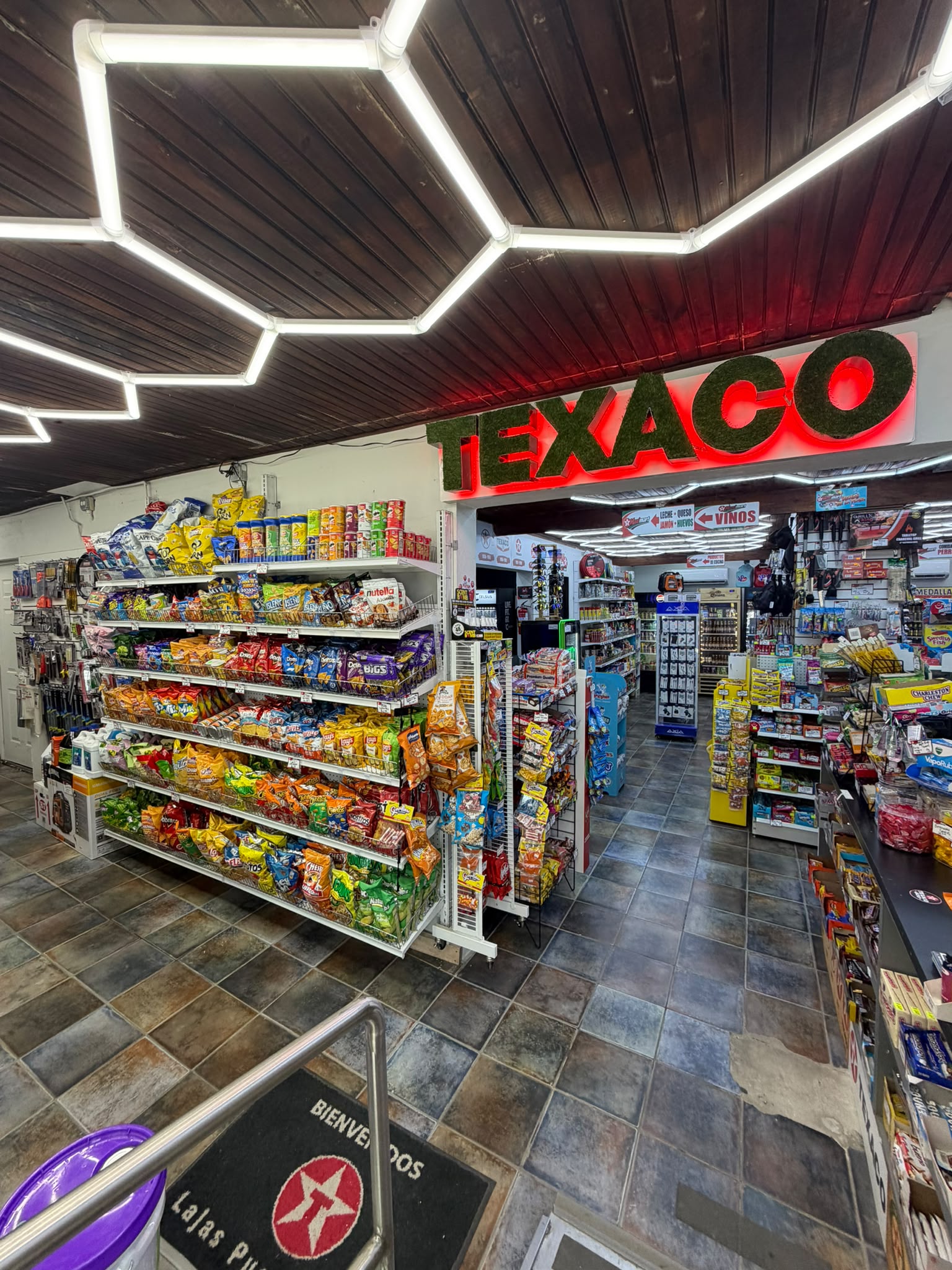 Interior de la tienda Texaco en Lajas con el letrero iluminado y pasillos de productos